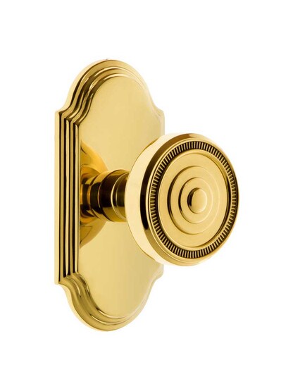 Grandeur Arc Rosette Door Set with Soleil Knobs in Polished Brass.